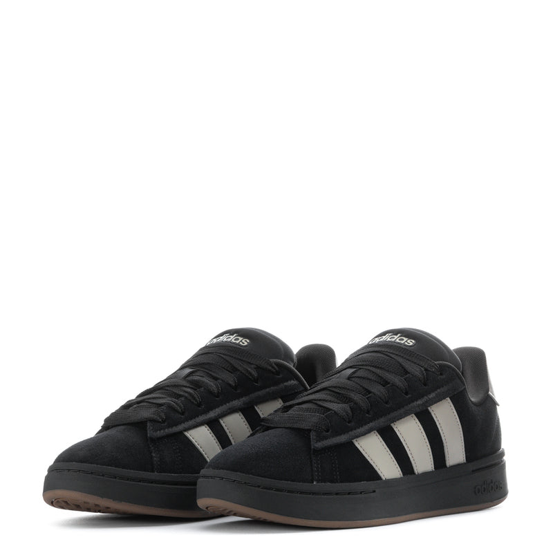 Pair of men’s black adidas sneakers with three white stripes and gum soles