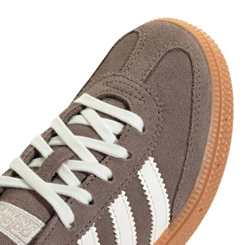 Kids suede sneaker upper close-up with white laces and serrated 3-stripe detail