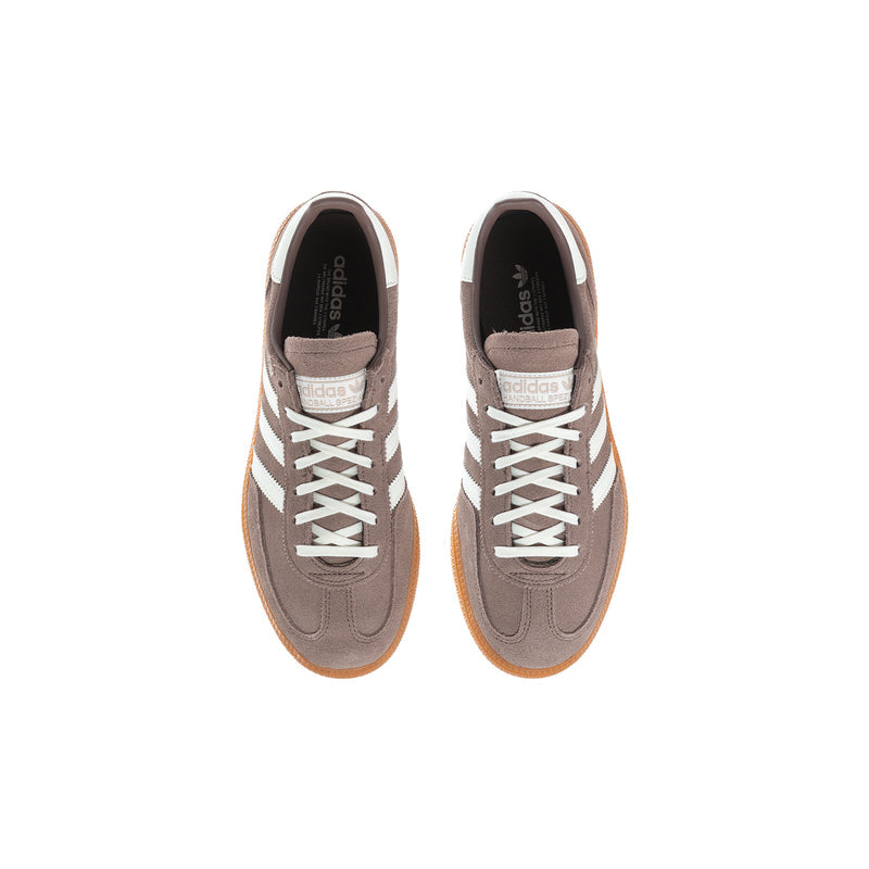 Youth sneakers pair, brown uppers with cream laces and orange gum soles.