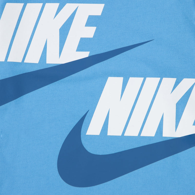 Close-up of blue T-shirt with large Nike and swoosh graphics in white and dark blue.
