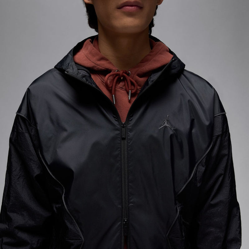 Black hooded draft jacket close-up with zipper front and drawstring hood