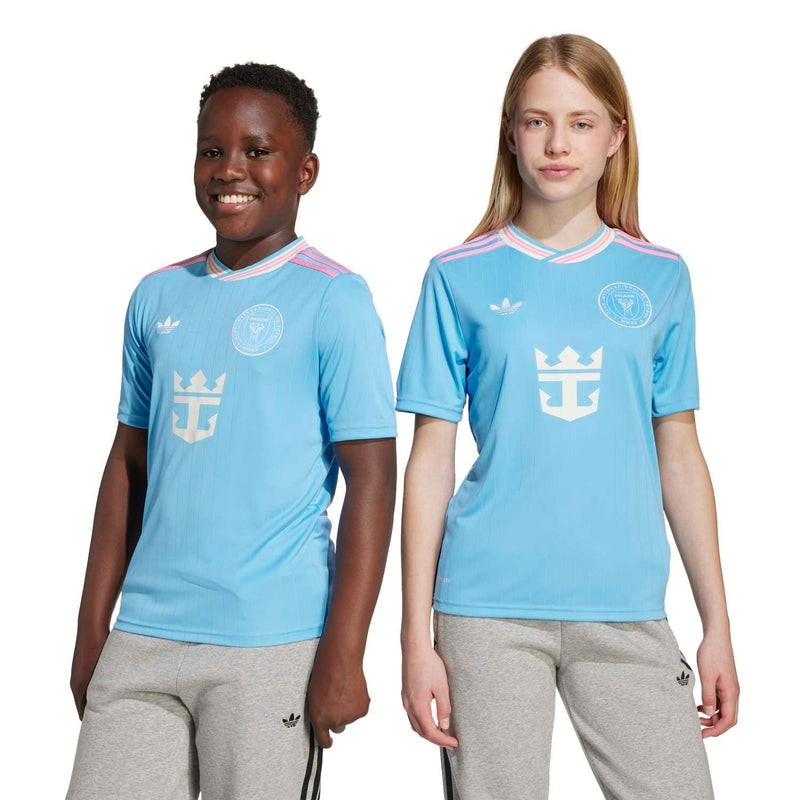 Youth light-blue soccer jersey with pink-and-white collar stripes, crest, and anchor logo