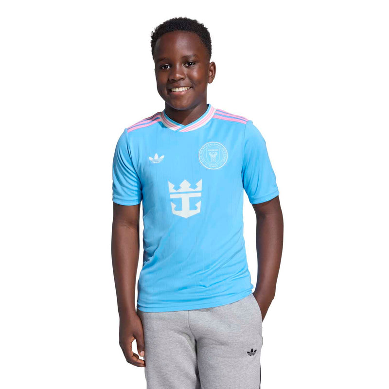 Youth light-blue soccer jersey with pink-and-white collar stripes and team crest