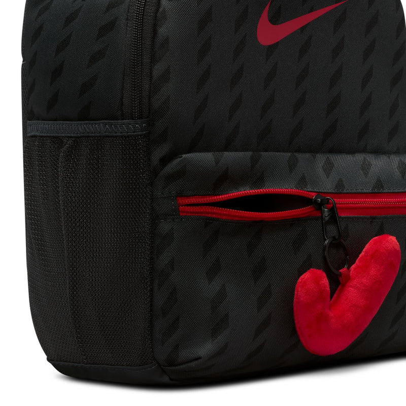 Mini black backpack close-up with red zipper, key loop, and plush red pull tag