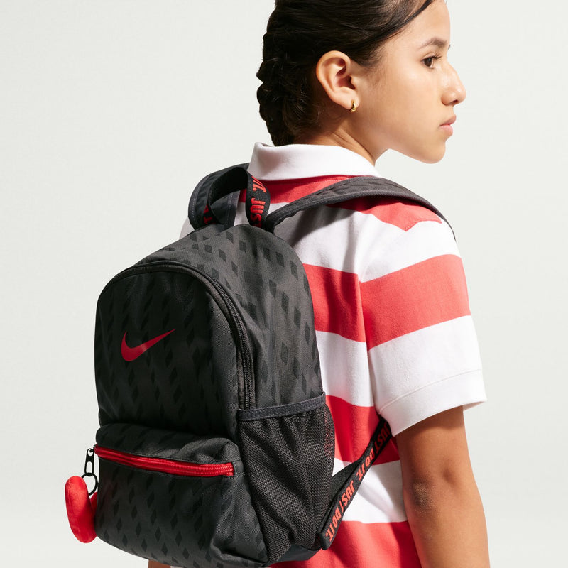 Mini black backpack worn on shoulder with red zipper accents and Nike swoosh