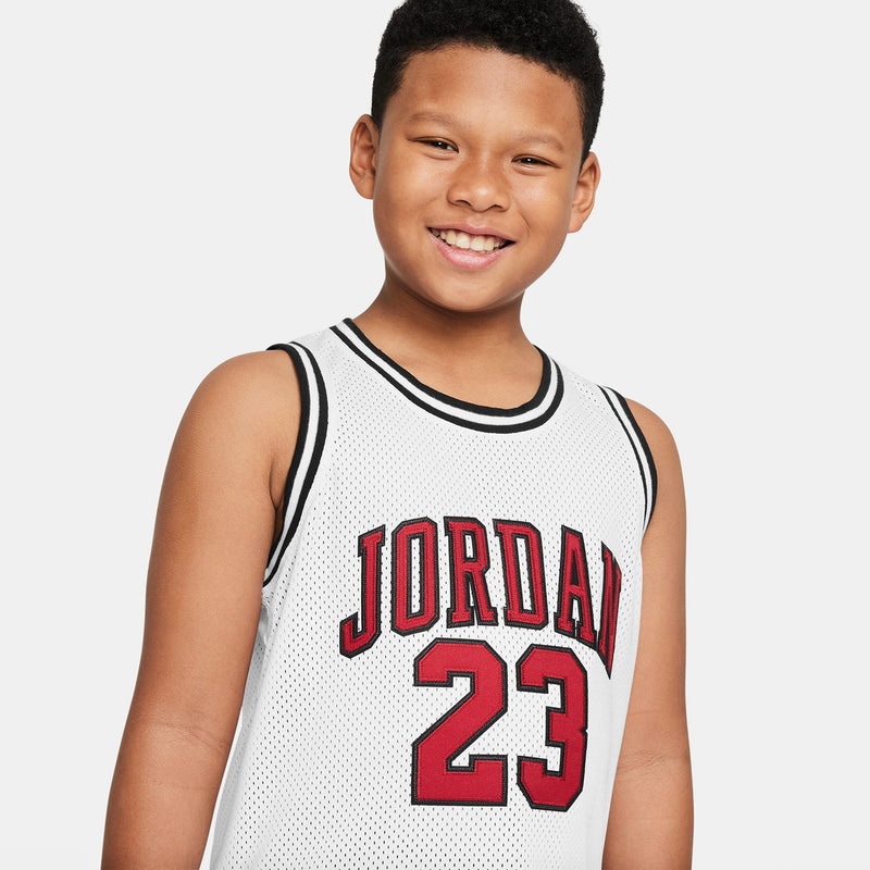 White youth basketball jersey close-up: red 'JORDAN' lettering and black '23' number