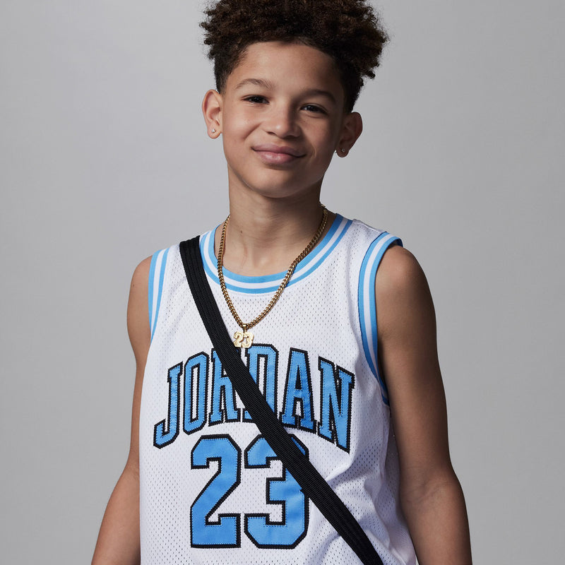 White youth basketball jersey close-up: Jordan 23 front graphic with light blue outline