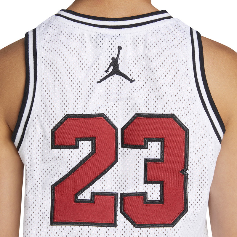 White youth basketball jersey back close-up: red '23' number with black outline