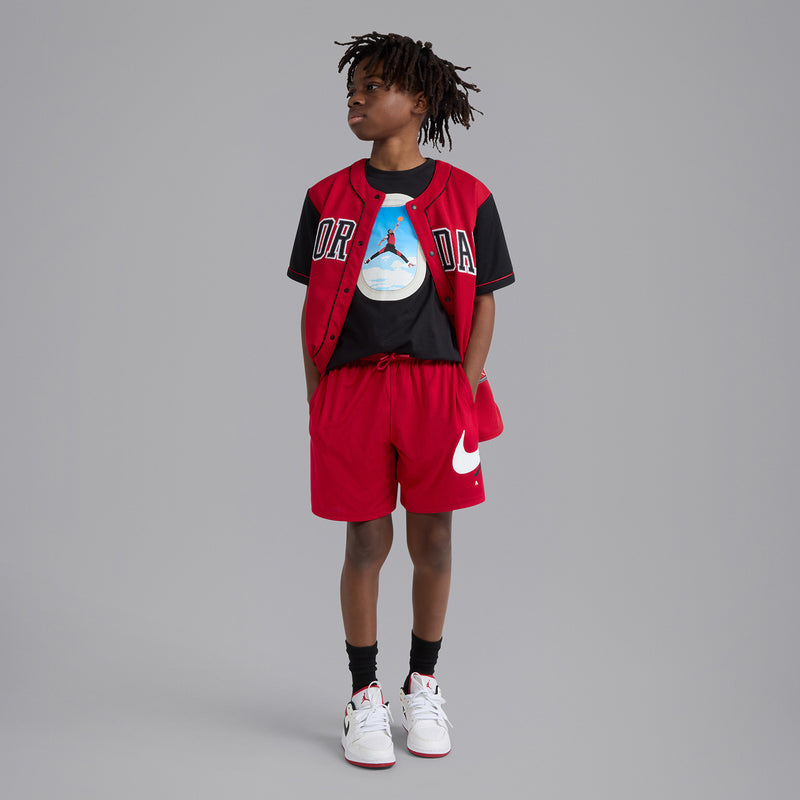 Youth Gym Red shorts with elastic waistband and Jordan logo, worn with sneakers