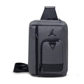 Iron grey crossbody bag with Jordan logo, top carry handle and adjustable strap
