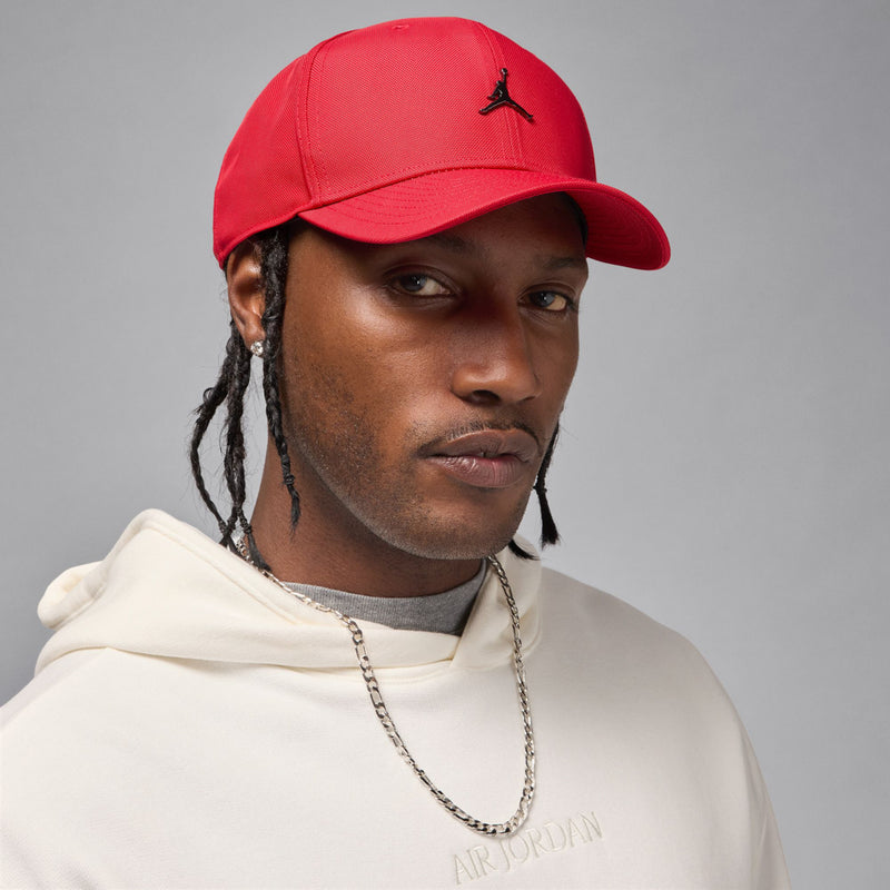 Red structured curved-bill cap with small Jumpman logo, worn on head