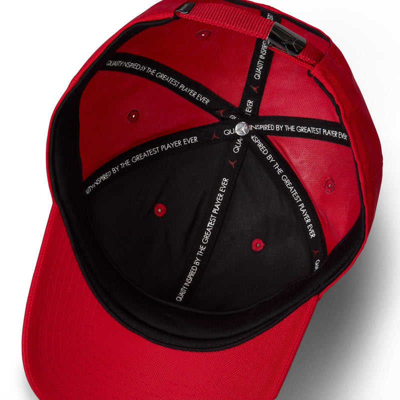 Red cap interior with black lining and adjustable strap, printed text panels