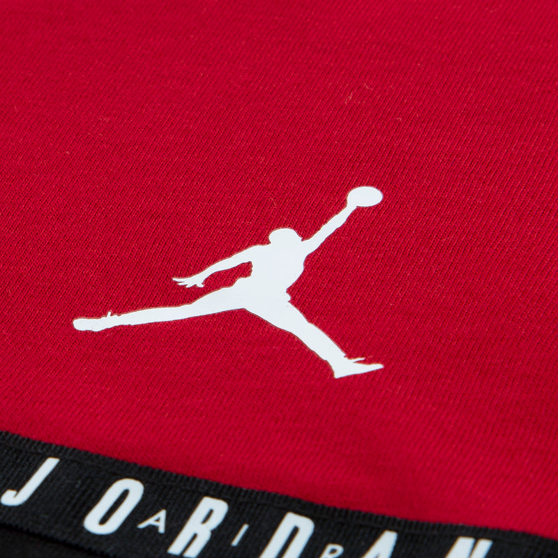Gym Red T-shirt fabric close-up with white Jordan Jumpman logo and black taping stripe