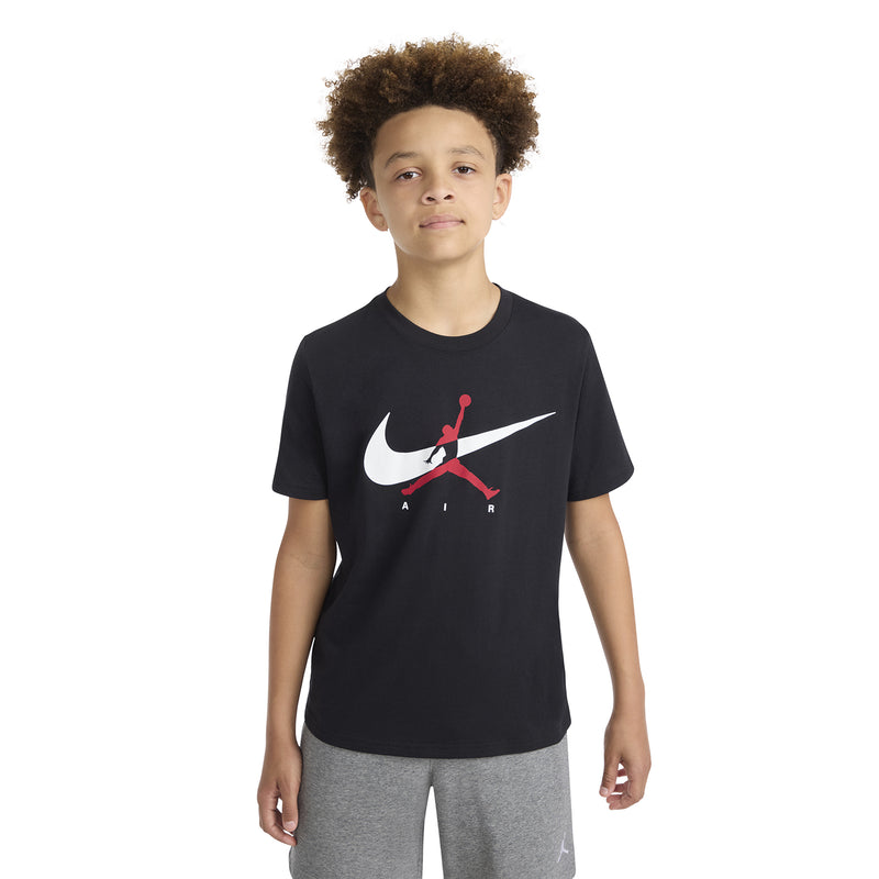 Black youth T-shirt on model, white swoosh and red Jumpman logo at center chest