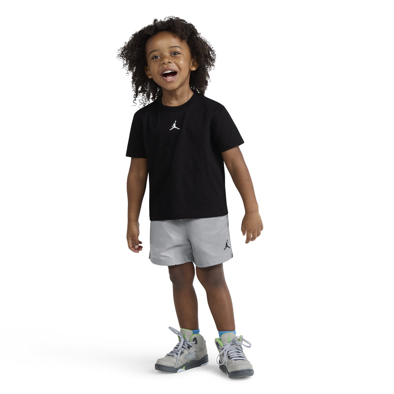 Toddler wearing black Jordan logo T-shirt and light gray pull-on shorts