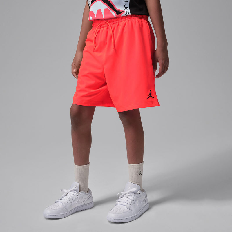 Youth Infrared red shorts on model, elastic waistband with drawstring and small Jumpman patch