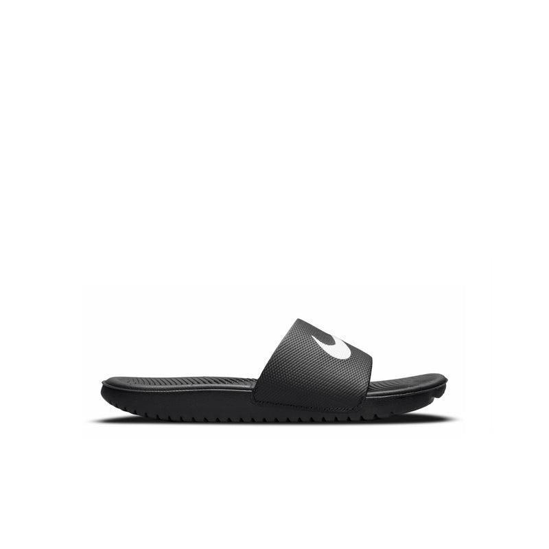 Kids black slide sandal side view with textured strap and white Nike swoosh