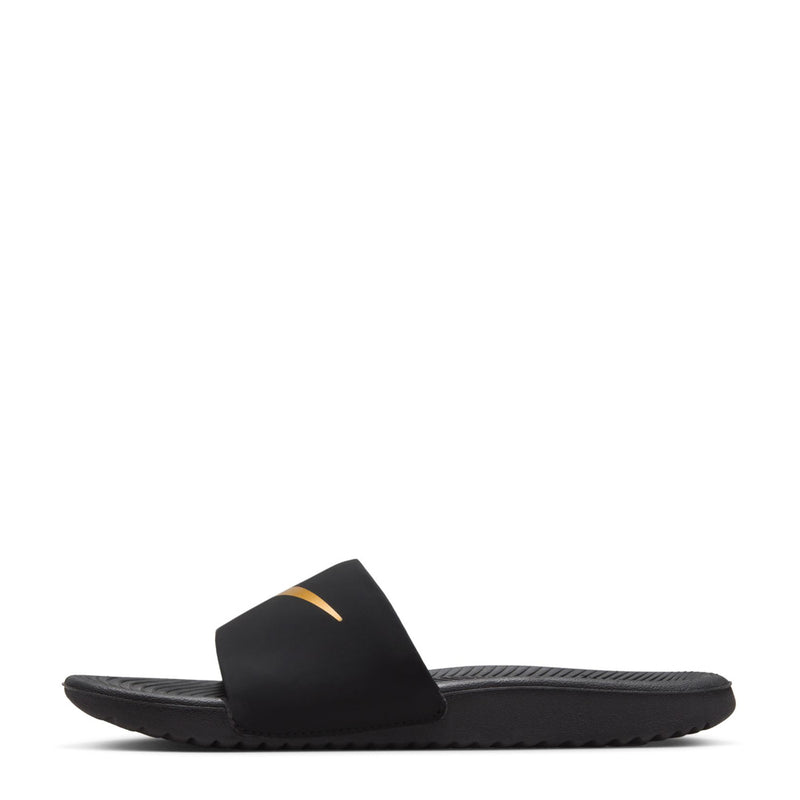 Kids' black slide sandals with gold swoosh, padded strap and ridged sole