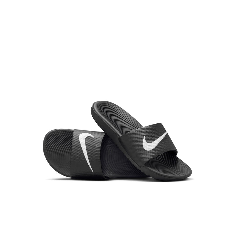 Kids black slide sandals angled view, white Nike swoosh on the strap