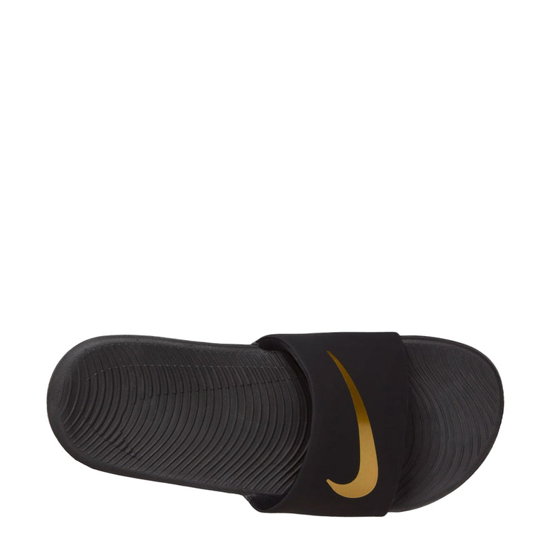 Kids' black slide sandals with gold swoosh on strap, ribbed sole tread
