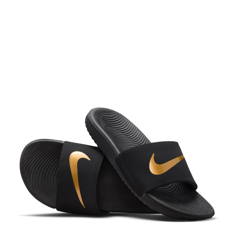 Youth slide sandals with textured footbed and Nike gold swoosh, angled view