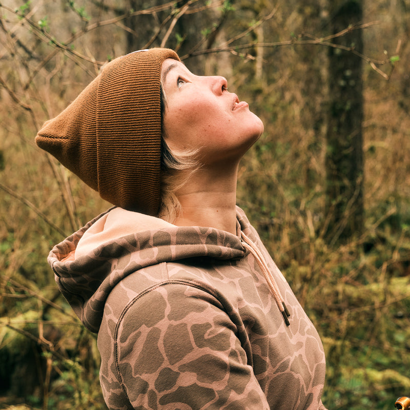 Carhartt brown knit beanie with folded cuff, logo patch visible.