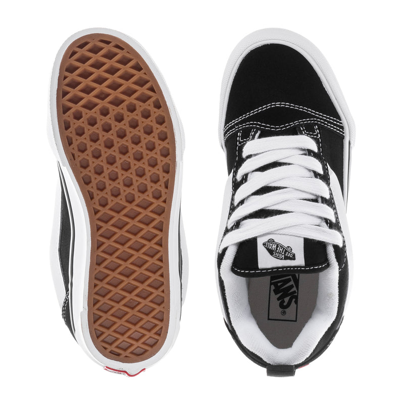 Kids black-and-white lace-up low-top skate shoes with treaded rubber outsole.