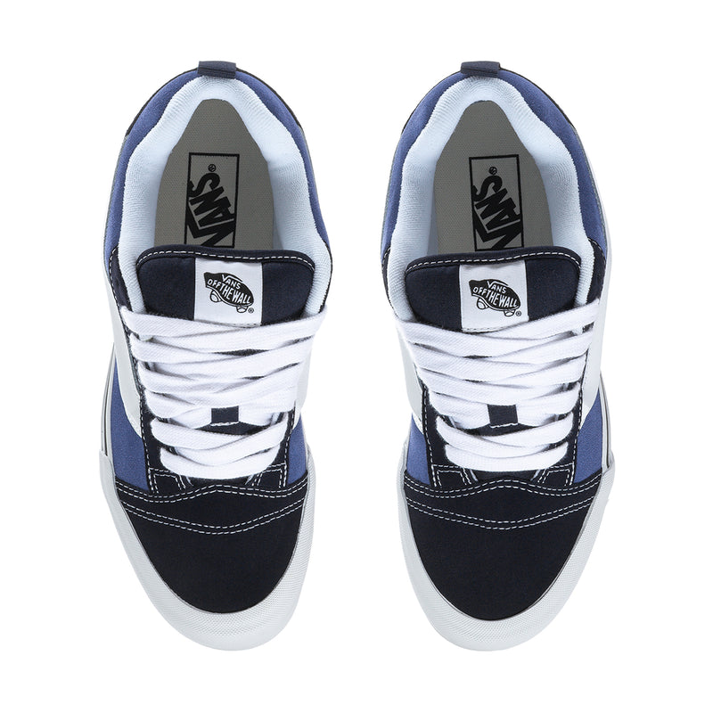 Men's navy and white sneakers viewed from heel; interior lining and tongue labels visible.