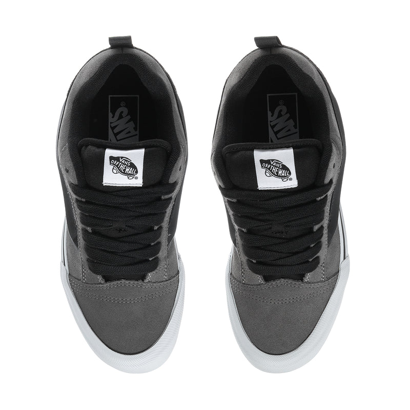 Men's sneaker tongue and collar with black laces and brand patch on pewter suede