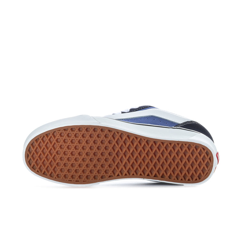 Men's navy and white sneaker outsole view with textured gum rubber tread.