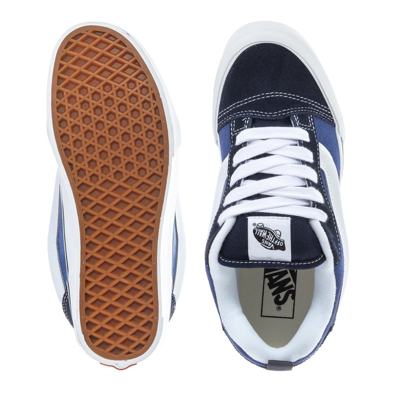 Youth sneakers underside shows tan waffle tread; navy-and-white uppers with Vans patch