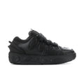 Black low-top sneakers with lace-up front and textured rubber sole