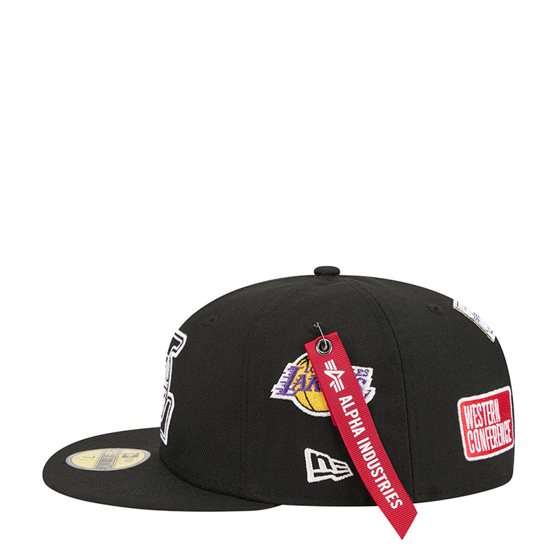 Black snapback cap with patch logos and red ribbon tag on the side
