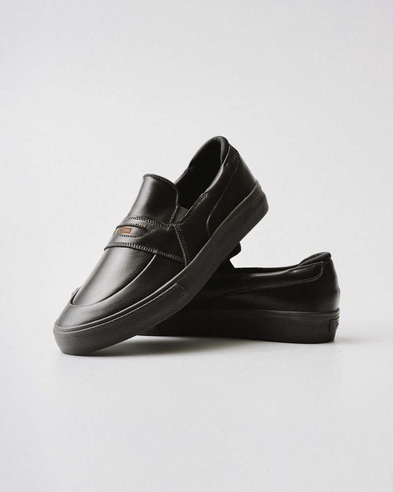 Liaizon Black Maalouf pull up leather skate shoe shown from the side with a brown logo tag on the vamp