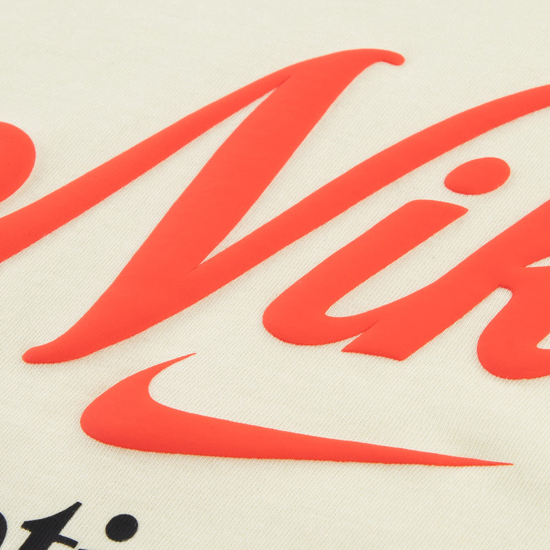 Cream T-shirt fabric closeup with red Nike logo print