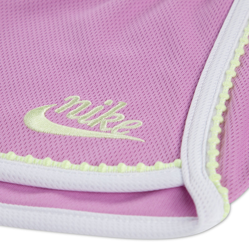 Light magenta toddler short with white trim and neon green logo on hem