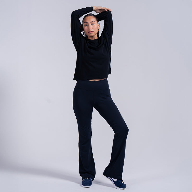 Women's black long-sleeve crewneck tee, cropped front view on model