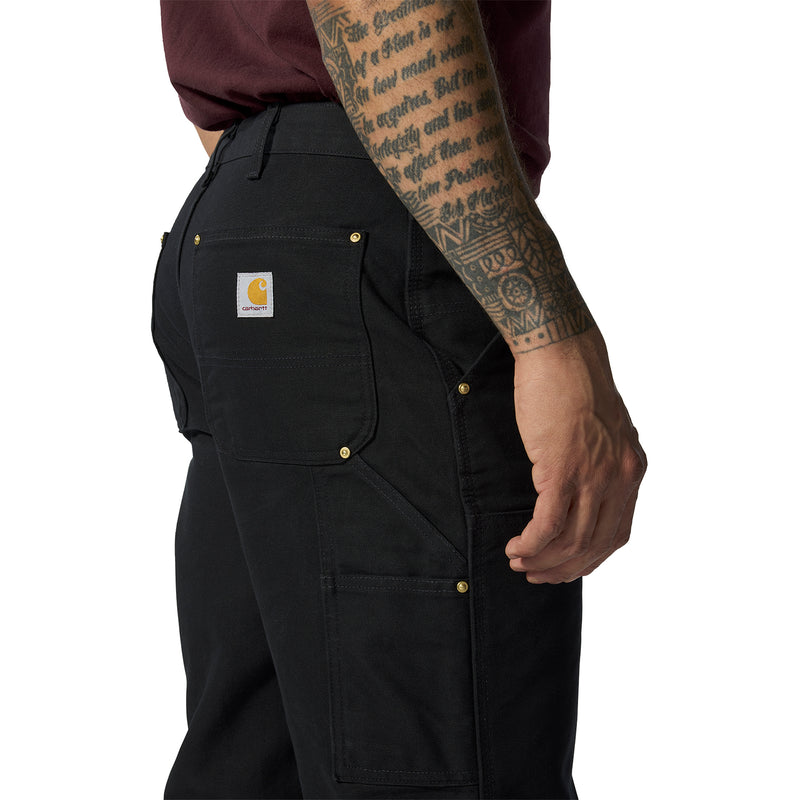 Black work dungaree pants close-up of thigh pocket flap and stitched paneling