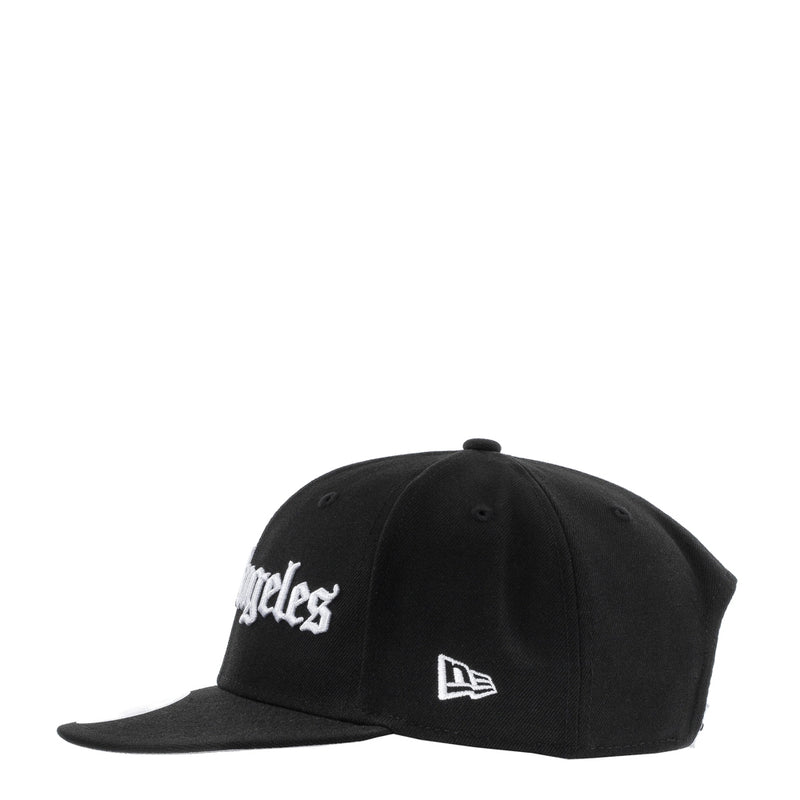 Black baseball cap with white Los Angeles script logo and New Era emblem