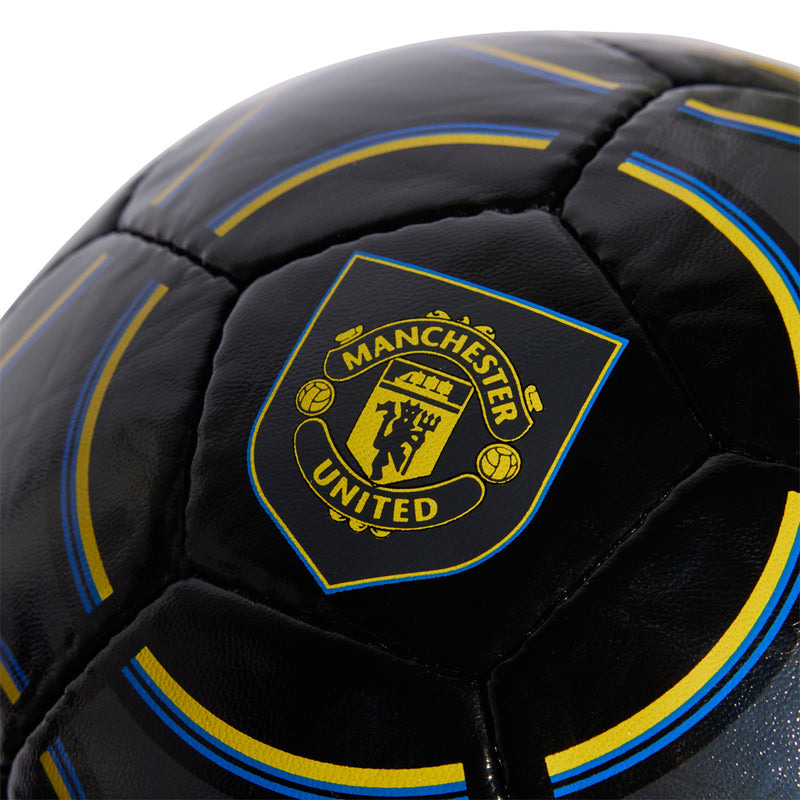 Manchester United crest on black football with blue and yellow outlined detailing