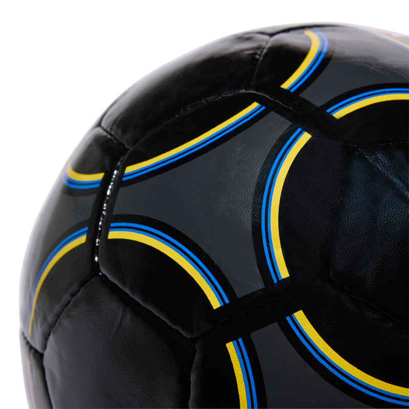 Black Manchester United football panel with blue and yellow stripe accents, angled close-up