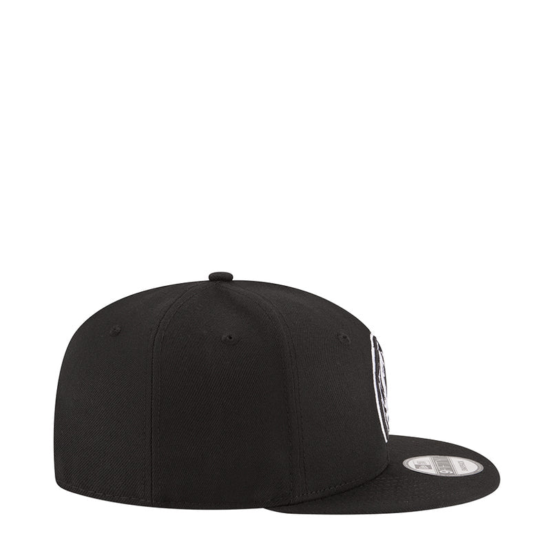 Black baseball cap side panel with partial white Mavericks logo
