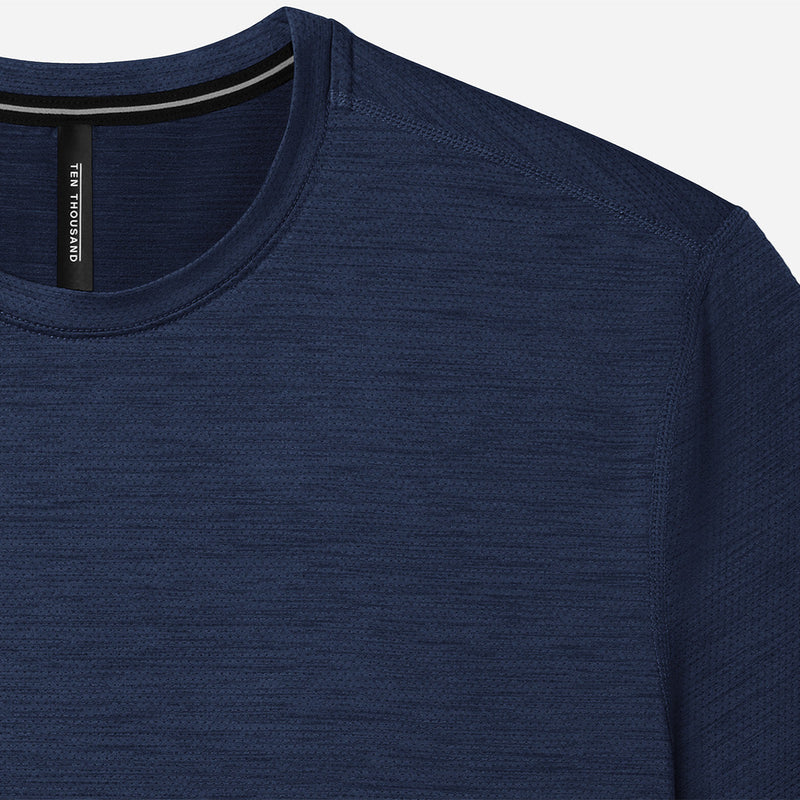 Close-up of a blue long-sleeve shirt with a brand label on a light gray background
