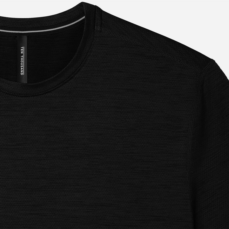 Close-up of a black ten thousand interval shirt with a brand label on a white background