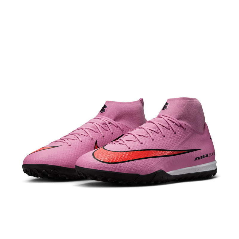 Men's pink turf soccer cleats, orange Nike swoosh and black trim, lace-up design
