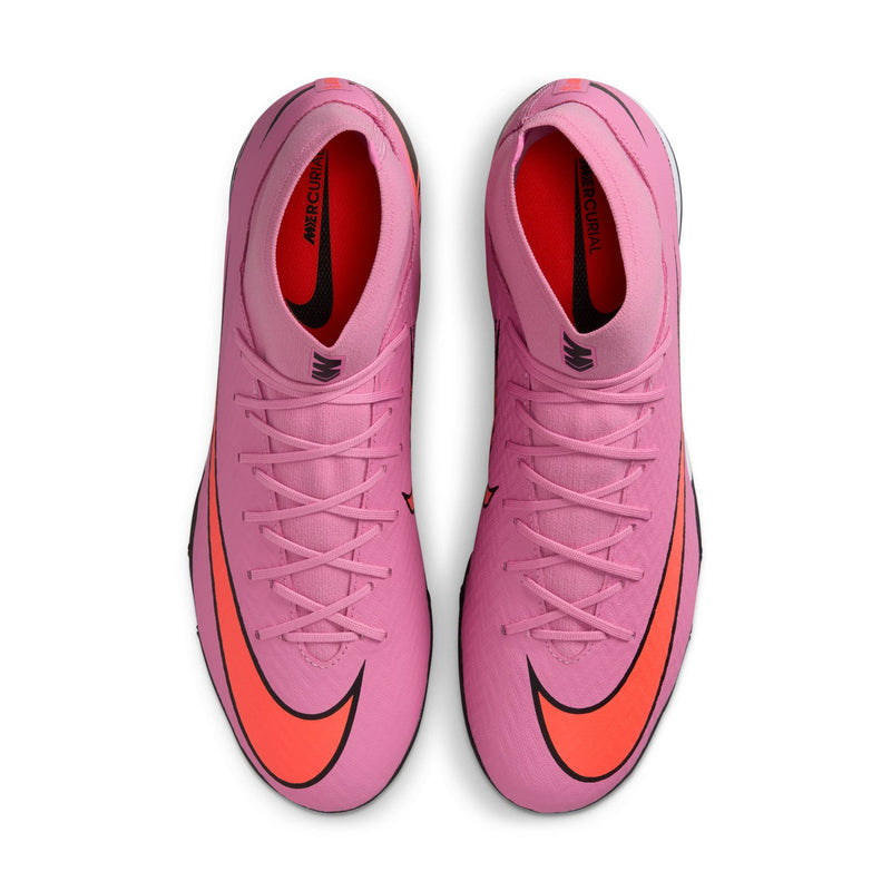 Pair of men's pink turf soccer cleats with orange swoosh accents and black logos