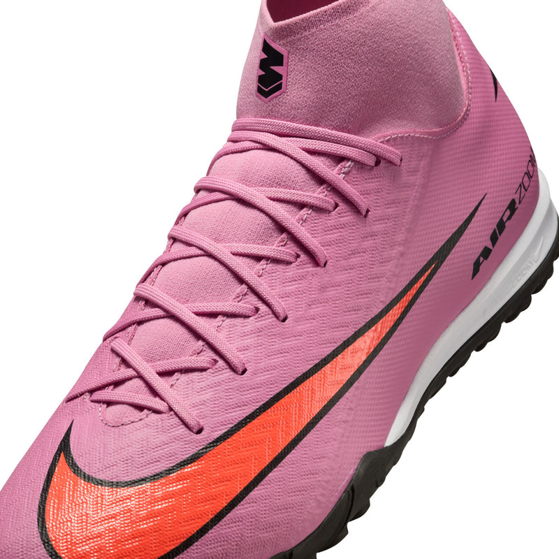 Close-up of men's pink turf soccer cleats: lace-up front, Nike swoosh, Air Zoom tag
