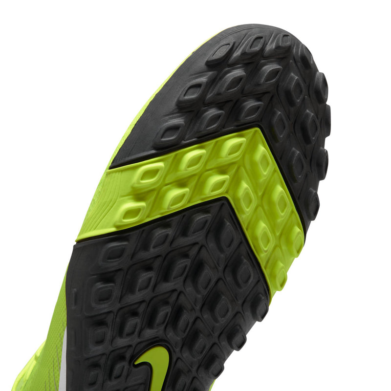 Close-up outsole tread of neon green and black turf soccer cleat with stud pattern