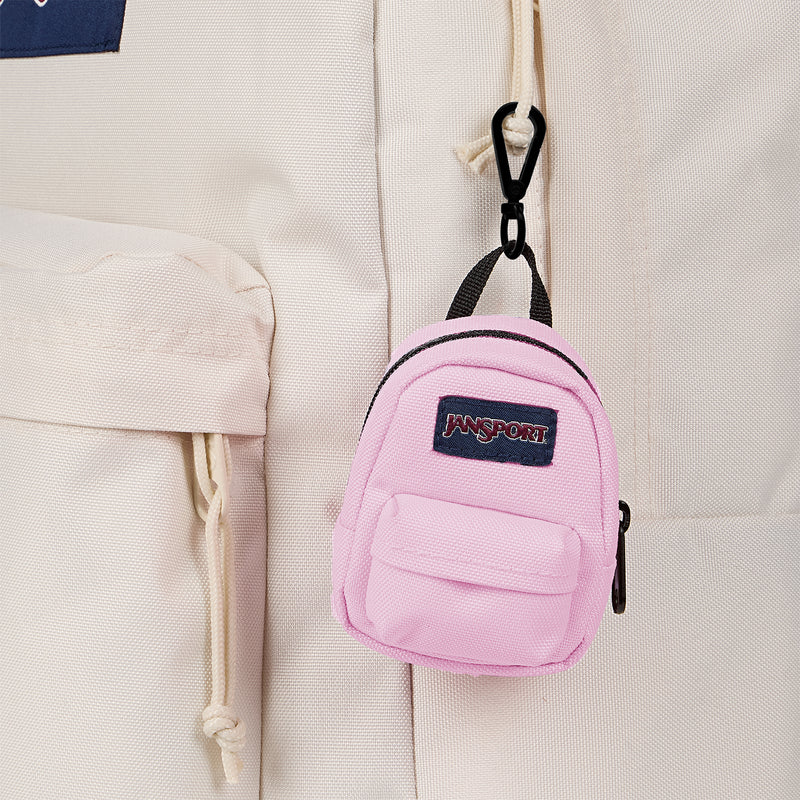 JanSport mini backpack in Pink Ice close-up of logo patch and front zipper pocket