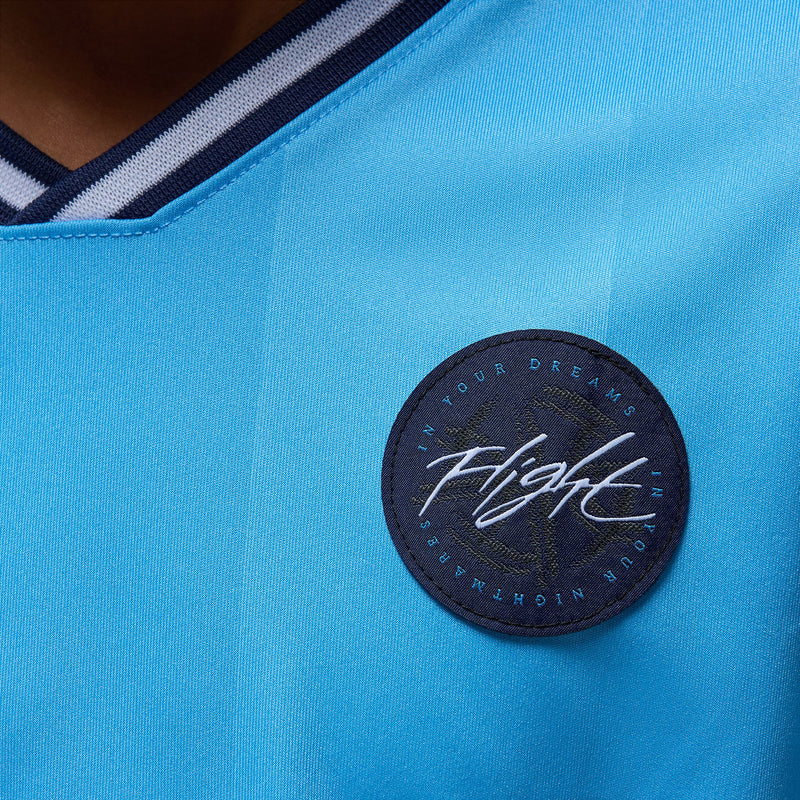 Youth light blue jersey, round black logo patch with 'flight' script